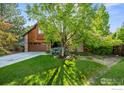 Inviting home with a lush green lawn, mature trees, and a brick and wood facade at 5430 Baca Cir, Boulder, CO 80301