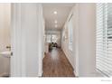 Bright hallway featuring modern floors and neutral walls, leading to the living area at 645 Flintwood Pl, Lafayette, CO 80026