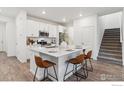 Bright kitchen with white cabinets, island with seating, and stainless steel appliances at 645 Flintwood Pl, Lafayette, CO 80026