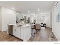 Open-concept living space with island seating, bright windows, and modern finishes at 645 Flintwood Pl, Lafayette, CO 80026