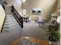 Open-concept living area with high ceilings, large windows, staircase, and elegant decor at 804 Nelson Park Ln, Longmont, CO 80503
