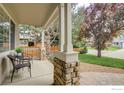 Relaxing front porch with comfortable seating and decorative stone pillars at 804 Nelson Park Ln, Longmont, CO 80503