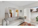 Open-concept living room with neutral tones, a patterned rug, and a view of the staircase and other rooms at 820 Kimbark St # D, Longmont, CO 80501