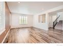 Spacious living room featuring hardwood floors, plantation shutters, and ample natural light at 8353 Bijou Creek Ave, Littleton, CO 80125