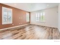 Bright living room with hardwood floors, neutral walls, and large windows with plantation shutters at 8353 Bijou Creek Ave, Littleton, CO 80125
