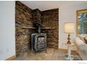 Close-up of a cozy wood-burning stove set against a stunning stone accent wall in the living room at 849 Mountain Meadows Rd, Boulder, CO 80302