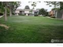 Townhomes surround a spacious and well-maintained front lawn in a community setting at 10350 Tumbleweed Dr # 32, Thornton, CO 80229