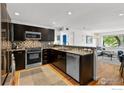 Modern kitchen with stainless steel appliances, dark cabinetry, and mosaic backsplash at 1201 Balsam Ave # 201, Boulder, CO 80304
