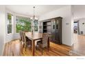 Bright dining room featuring a chandelier, hardwood floors, and large window at 13420 Spruce St, Thornton, CO 80602