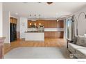 Open concept kitchen with stainless steel appliances, island, and hardwood floors at 13420 Spruce St, Thornton, CO 80602