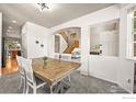 Inviting dining room with hardwood table, white chairs, and seamless flow into adjacent living spaces at 13445 Kearney St, Thornton, CO 80602