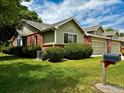 Side angle of house with combination brick and green siding and a two-car garage at 1515 Tulip Ct, Longmont, CO 80501