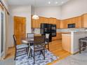 Eat-in kitchen with stainless appliances, breakfast bar, and wood cabinets at 1536 Goshawk Dr, Longmont, CO 80504