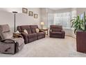 Relaxing living room boasts plush seating, neutral carpet and bright natural light at 1536 Goshawk Dr, Longmont, CO 80504