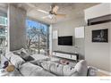 Relaxing living room with large windows, a modern ceiling fan, and a stylish gray sofa at 1700 Bassett St # 903, Denver, CO 80202