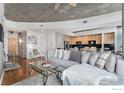 Spacious living room with modern décor, gray sectional sofa, and open kitchen area at 1700 Bassett St # 903, Denver, CO 80202