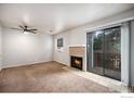 Inviting living room with cozy fireplace, sliding glass door to balcony, and neutral carpet at 225 E 8Th Ave # C-19, Longmont, CO 80504