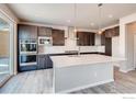 Modern kitchen featuring stainless steel appliances, dark cabinets, and a large island with a white countertop at 2718 Crystal Springs Ln, Longmont, CO 80503