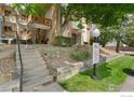 Apartment building exterior with landscaped front and stairway to the units at 2835 S Monaco Pkwy # 104, Denver, CO 80222