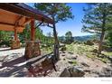 Picturesque view from a cozy porch with stone pillars, overlooking a vast, lush landscape filled with trees and boulders at 409 Wild Horse Cir, Boulder, CO 80304