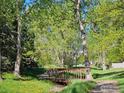 Peaceful park setting with a wooden bridge over a creek surrounded by lush greenery and trees at 4749 White Rock Cir # D, Boulder, CO 80301
