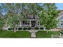 Inviting two-story home with a cozy front porch and a well-maintained lawn at 5111 Mt St Vrain Ave, Frederick, CO 80504