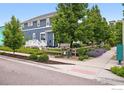 A charming two-story home features manicured landscaping, lush trees, and a well-maintained sidewalk, creating a welcoming curb appeal at 518 Hoyt Ln, Lafayette, CO 80026