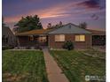 Charming brick home with a well-maintained lawn and pathway leading to the entrance at dusk at 547 S Eliot St, Denver, CO 80219