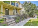 Inviting covered front porch with seating, showcasing a landscaped front yard at 634 Homestead St, Lafayette, CO 80026