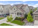 Beautiful home with well maintained lawn, landscaping, and a charming front porch with white railings at 767 Cabot Dr, Erie, CO 80516