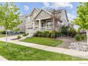 Inviting home showcasing a well-kept lawn, stone accents, and a cozy front porch at 767 Cabot Dr, Erie, CO 80516