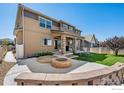 Inviting backyard with fire pit and brick surround for outdoor gatherings and relaxation at 775 Longs Peak Dr, Erie, CO 80516