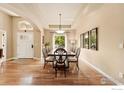 Elegant dining room featuring hardwood floors, tray ceilings, and a large window at 10882 Legacy Ridge Way, Westminster, CO 80031