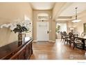 Inviting entryway with hardwood floors, a decorative table, and a view into the dining room at 10882 Legacy Ridge Way, Westminster, CO 80031