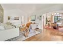 Open living room with wood floors, white walls, views to the dining room and comfortable seating at 1226 Dexter St, Denver, CO 80220