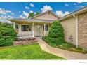 Inviting front exterior featuring a cozy porch with beautiful landscaping and decorative features at 13112 Summit Grove Pkwy, Thornton, CO 80241