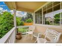 Relaxing front porch with chairs offers a serene outdoor seating area with lots of foliage at 13112 Summit Grove Pkwy, Thornton, CO 80241
