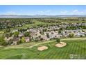 An aerial view shows the neighborhood, golf course, mountains, and landscaping at 1826 Lochmore Dr, Longmont, CO 80504