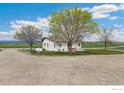 Quaint single-story home with well-maintained lawn and mature trees, situated on a spacious lot at 19810 County Road 1, Berthoud, CO 80513