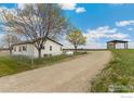 View of the home showing yard, detached building and propane tank at 19810 County Road 1, Berthoud, CO 80513