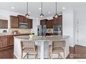 Modern kitchen with stainless appliances, island, and stylish pendant lighting at 2211 Winding Dr, Longmont, CO 80504