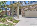 Inviting front porch with stone pillars, a seating area, and a charming wreath on the front door at 2312 Dogwood Dr, Erie, CO 80516
