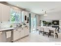 Bright kitchen with white cabinets, stainless steel appliances, and an adjacent dining area at 2312 Dogwood Dr, Erie, CO 80516