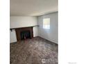 Living room featuring a fireplace, neutral carpet, and a bright window at 2449 Linden St, Longmont, CO 80501