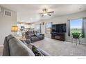 Spacious living room with plush seating, a fireplace, neutral walls, and abundant natural light at 2509 Alto St, Fort Lupton, CO 80621