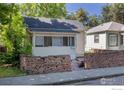 Charming single-story home featuring a red brick retaining wall and cozy, enclosed porch at 29 Marshall Pl, Longmont, CO 80504