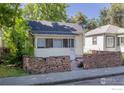 Charming single-story home featuring a red brick retaining wall and cozy, enclosed porch at 29 Marshall Pl, Longmont, CO 80504