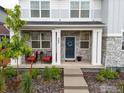 Inviting front porch with seating, a wreath on the door, and stone accents on the columns at 364 Fickel Farm Trl, Berthoud, CO 80513