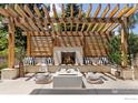 Cozy outdoor living space with a stone fireplace, wooden pergola, and comfortable seating at 3681 Paonia St, Boulder, CO 80301
