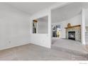 Bright living room with a cozy stone fireplace and carpeted floors at 3807 Paseo Del Prado, Boulder, CO 80301